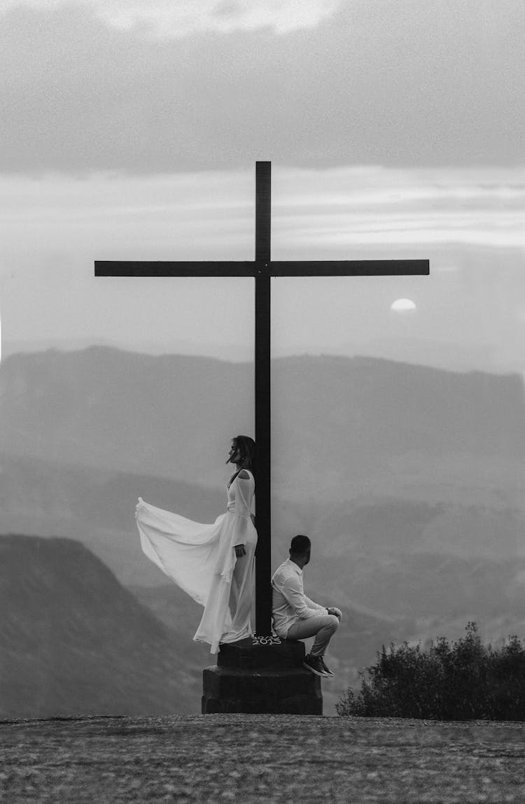 Man And Woman Pose On A Cross Monument