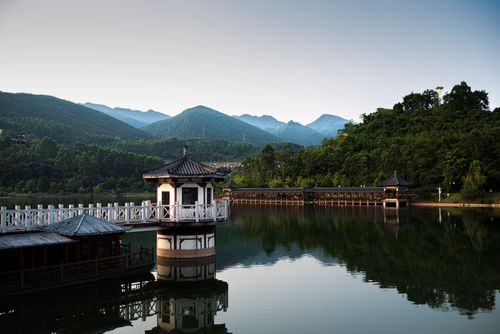 Free Peaceful lakeside scene with pavilion and bridge in Chongqing, China, surrounded by lush mountains. Stock Photo