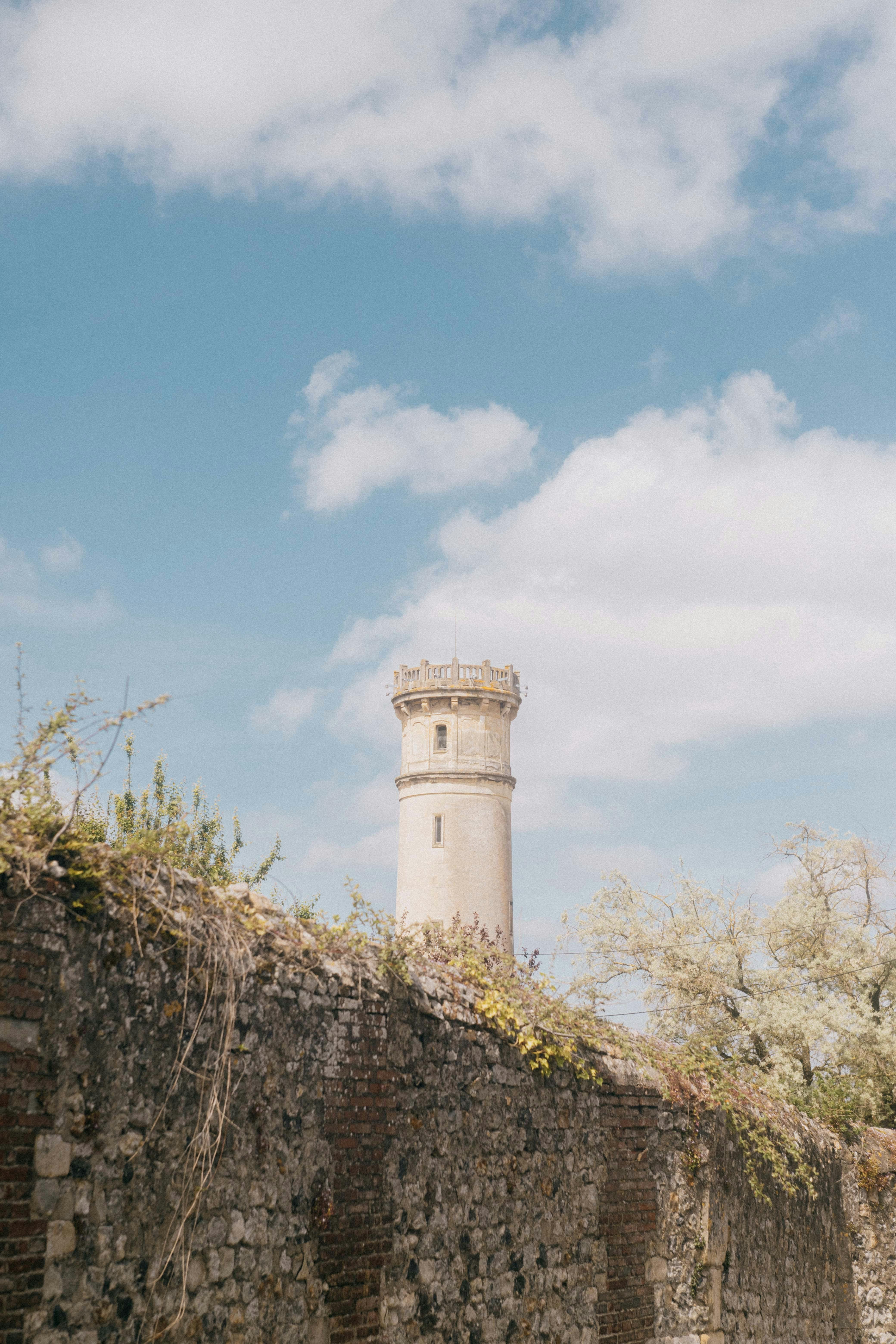 Charming view of a lighthouse in Honfleur, France, against a bright blue sky.