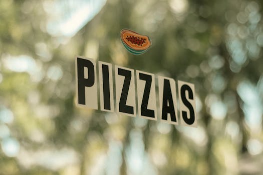 Window sign reading 'PIZZAS' with a blurred outdoor background, conveying a subtle advertisement vibe.