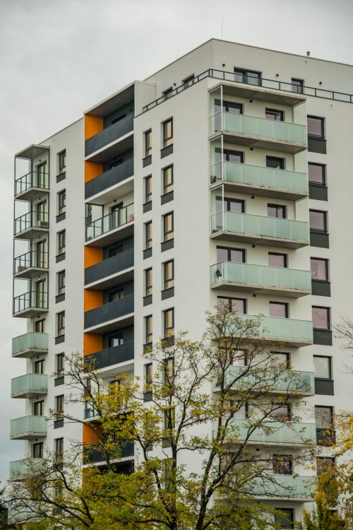 Free Contemporary apartment building with balconies and trees in urban setting. Stock Photo