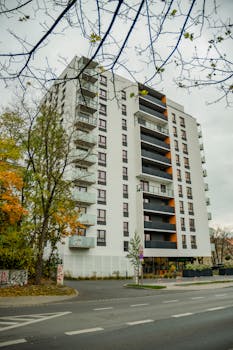 Contemporary apartment building with fall foliage in cityscape.