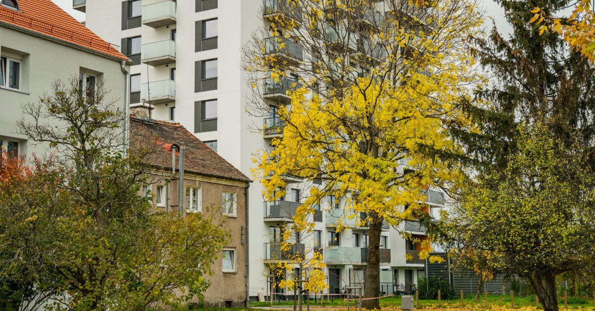 Autumn scene of residential buildings surrounded by colorful trees.