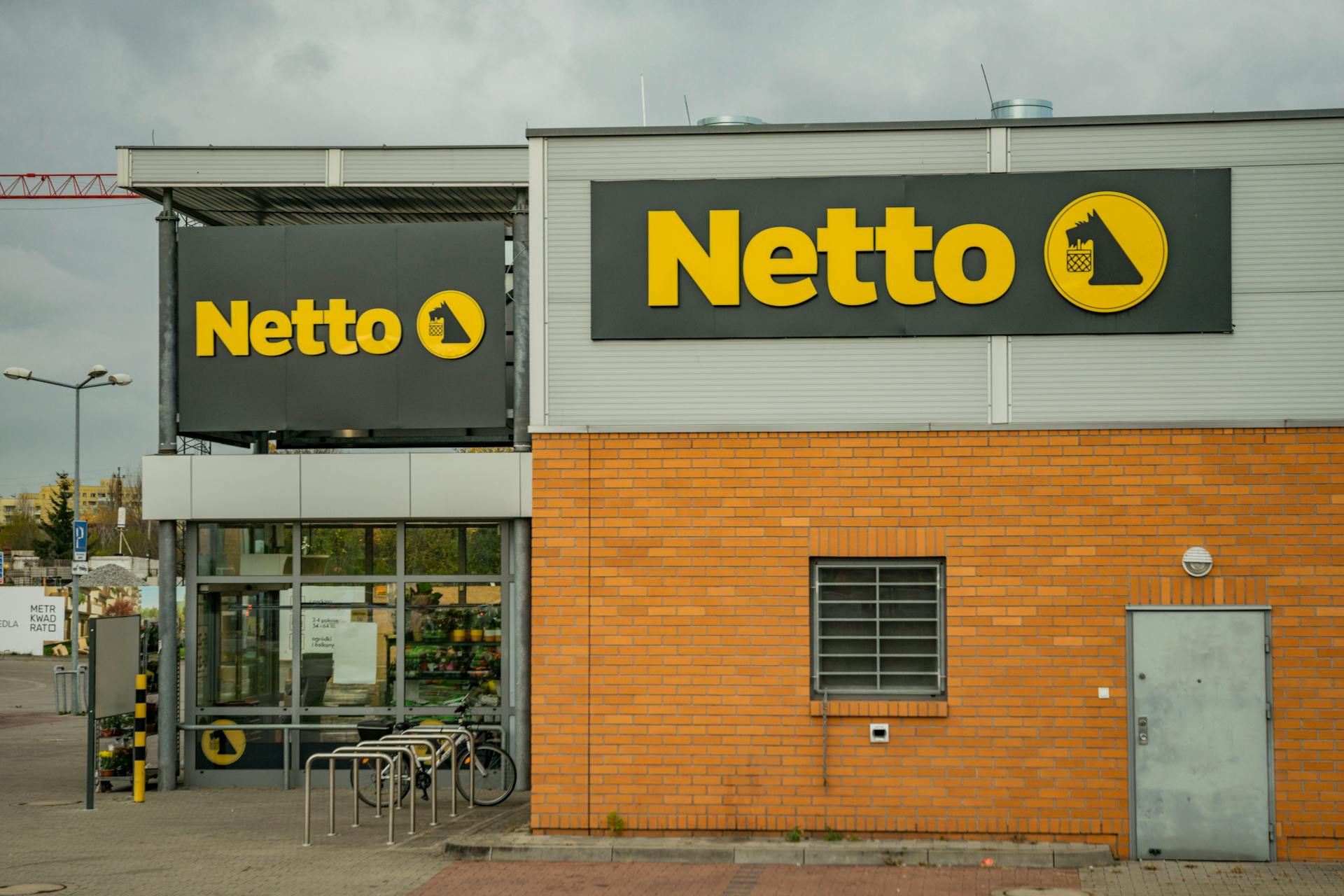 View of Netto supermarket exterior showcasing bold yellow logo signage.