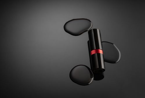 Free Stylish black lipstick on dark background with artistic water droplets. Stock Photo