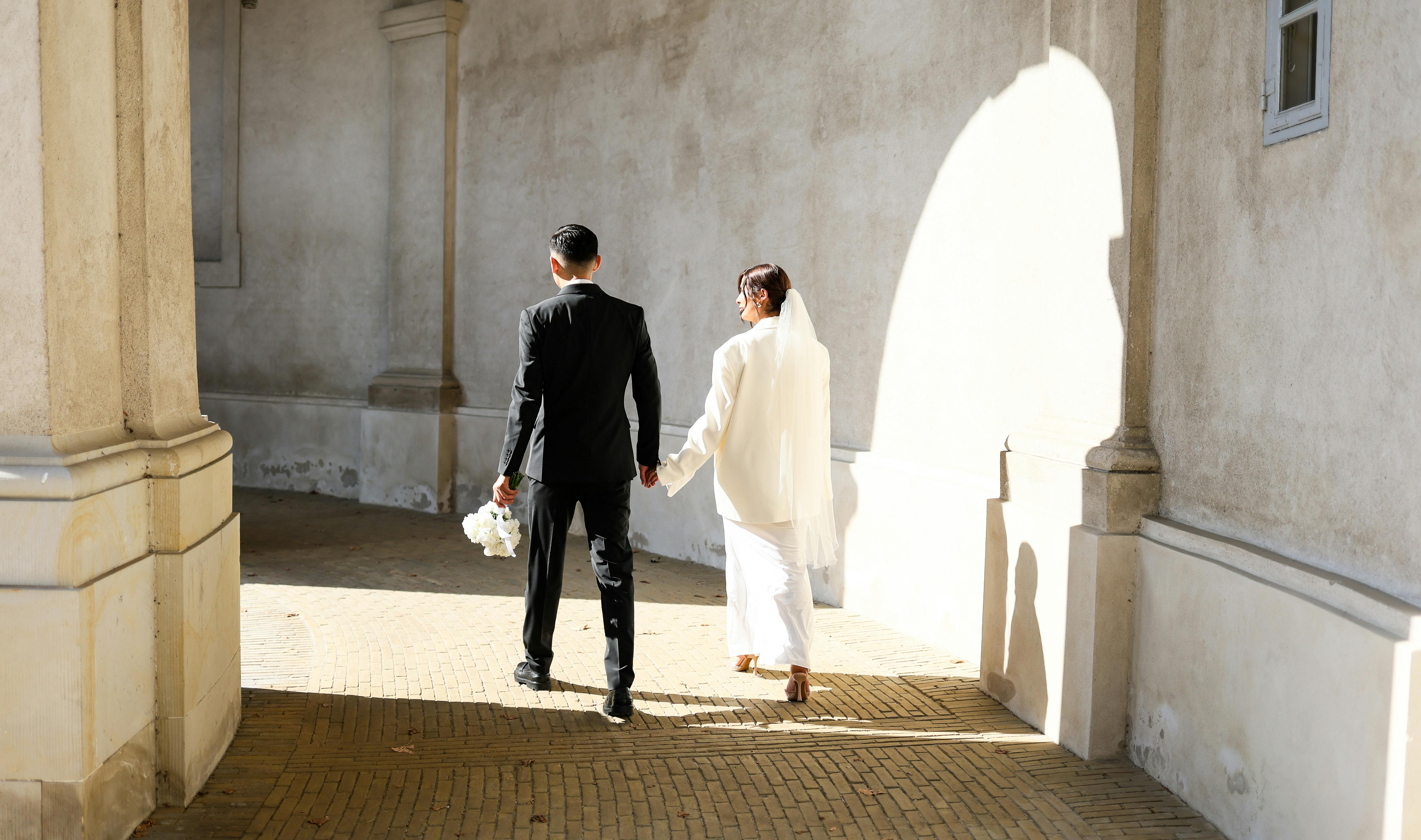 https://www.pexels.com/photo/elegant-wedding-couple-in-sunlit-corridor-29175675/