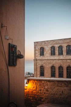 Serene view of historic stone buildings with a sunset-tinged sky, showcasing Mediterranean charm.