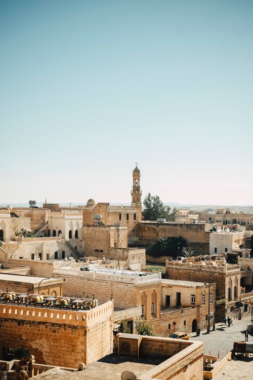 Free Scenic view of Midyat's historic stone architecture under clear blue sky, showcasing ancient cultural heritage. Stock Photo