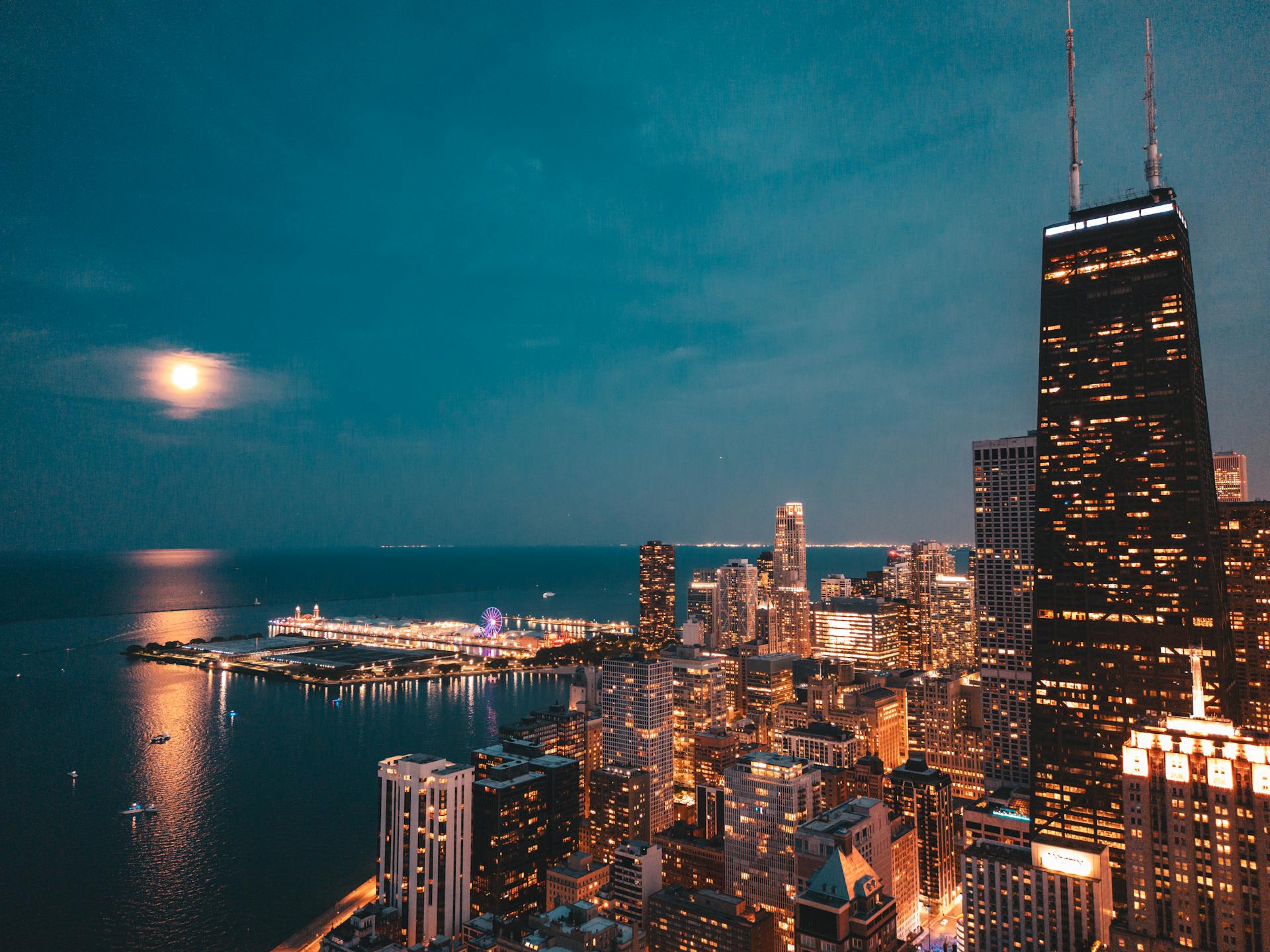 Stunning aerial view of Chicago skyline under a full moon with lakefront lights.