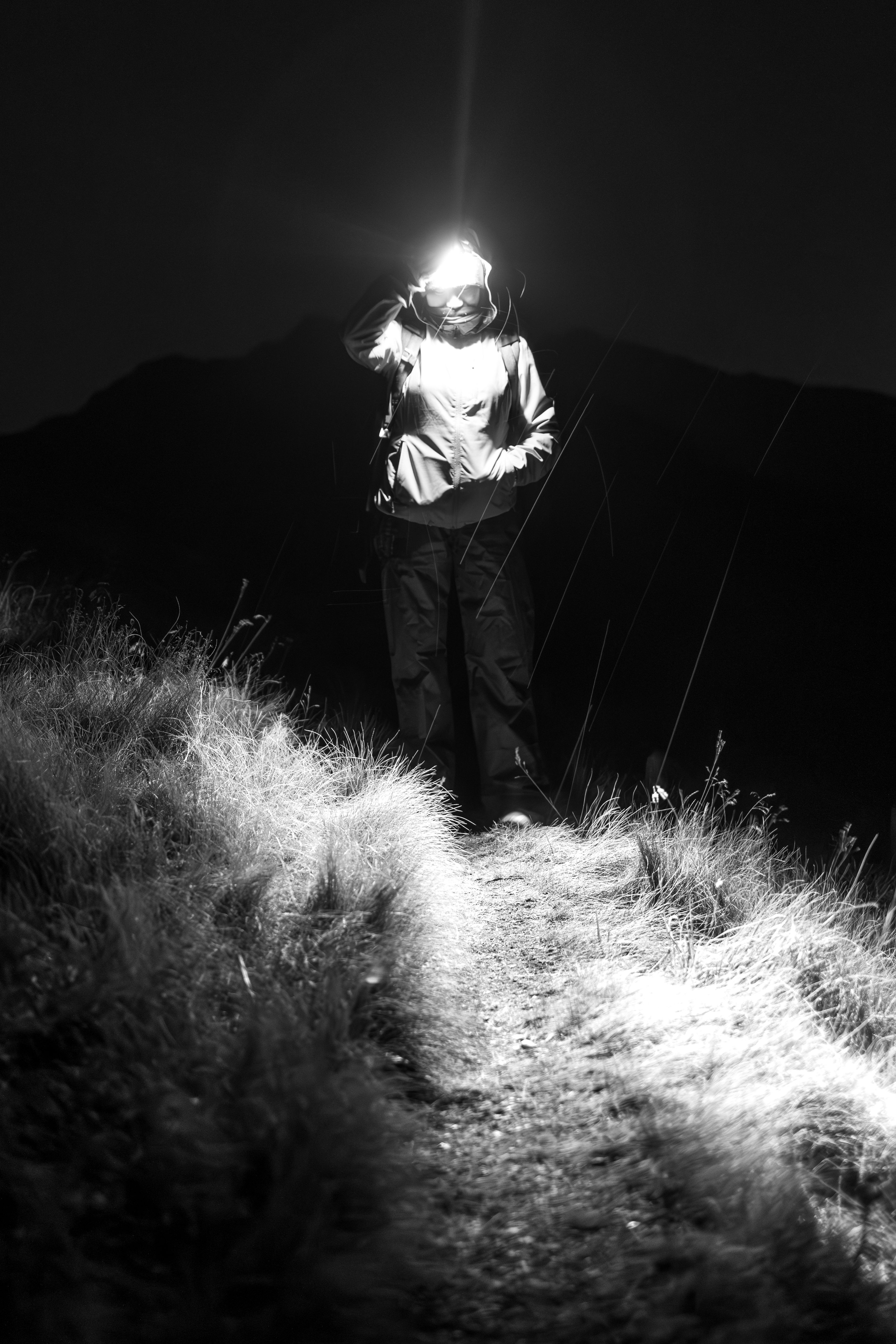 Hikers walking up Mount Batur volcanic trail with headlamps in the pre-dawn darkness during a Bali sunrise trek