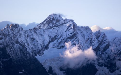 Free Breathtaking view of a snow-covered mountain peak with dramatic clouds at sunset in Italy. Stock Photo