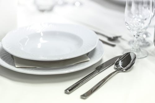 Round White Ceramic Bowl Placed on Table Beside Wine Glass