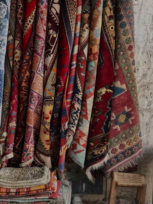Free A collection of colorful traditional patterned rugs displayed indoors, showcasing intricate designs and rich textures. Stock Photo