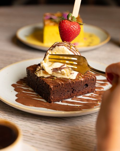 Free Close-up of a chocolate brownie topped with ice cream and a strawberry, perfect for dessert lovers. Stock Photo