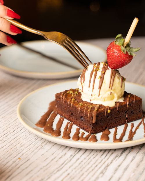 Free Scrumptious chocolate brownie topped with vanilla ice cream and a fresh strawberry. Stock Photo