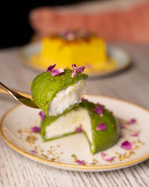 Free Exquisite green dessert topped with edible flowers, showcasing a creative culinary presentation. Stock Photo