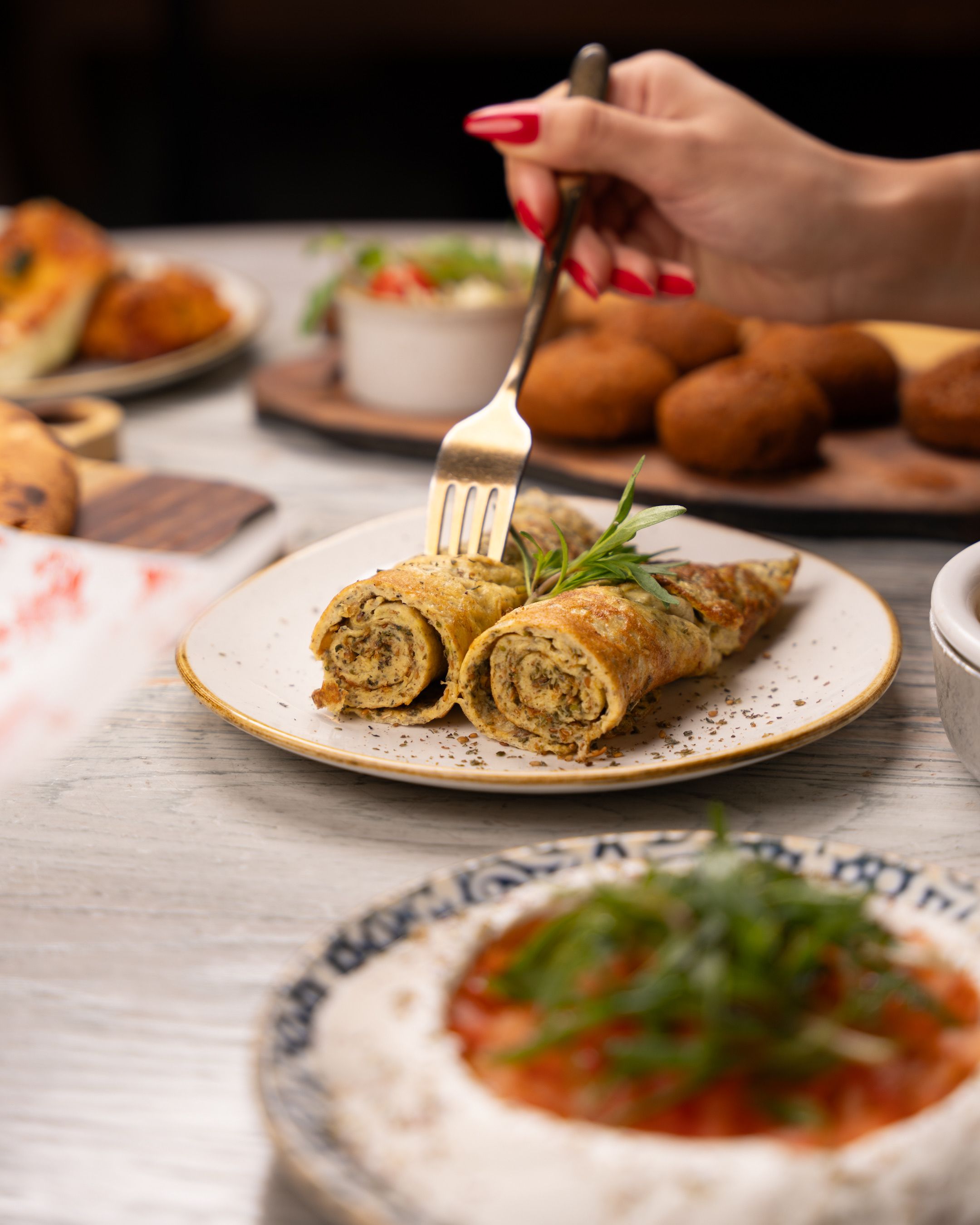 Delicious rolled crepes on plate, garnished with parsley, perfect for brunch or dinner.