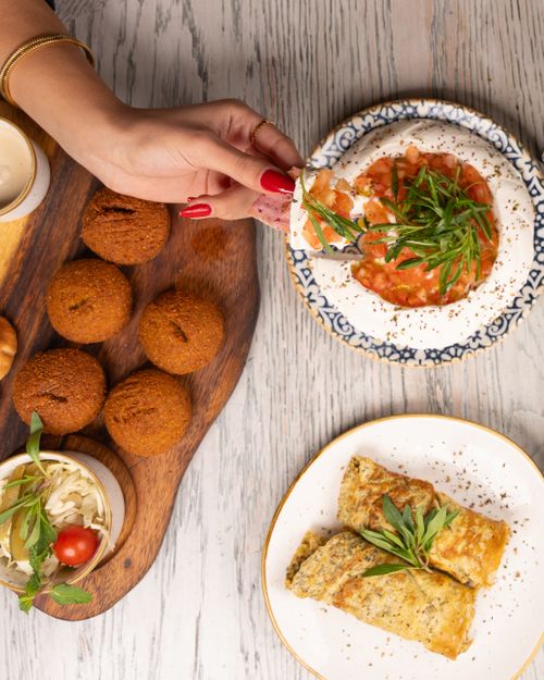 Free Top view of Middle Eastern meze with falafel, hummus, and omelette. Stock Photo