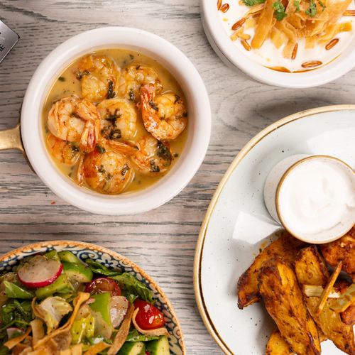 Free An enticing spread of Mediterranean shrimp, salad, and sauce on a rustic table. Stock Photo