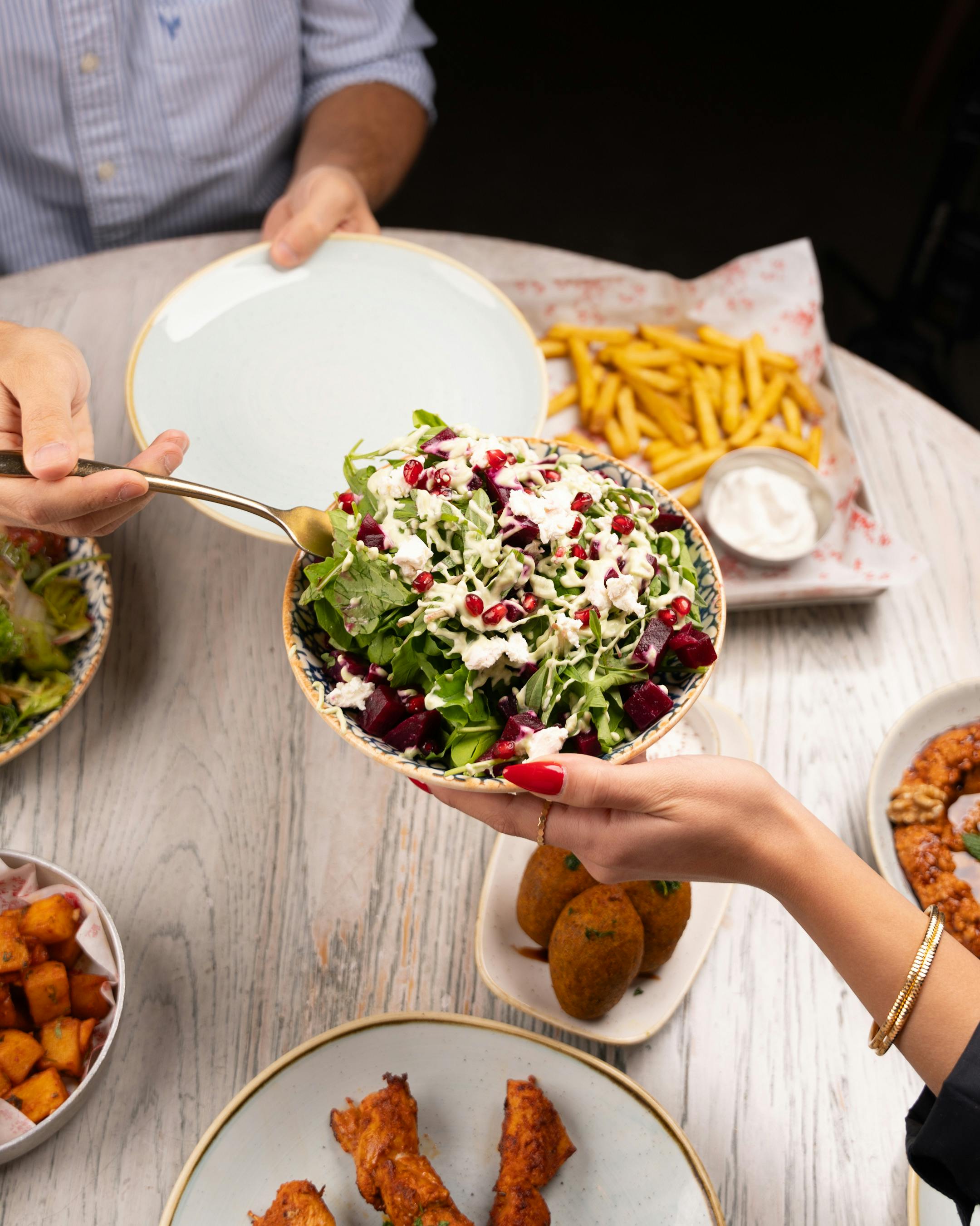 Vibrant Meal Sharing with Salad and Fries · Free Stock Photo