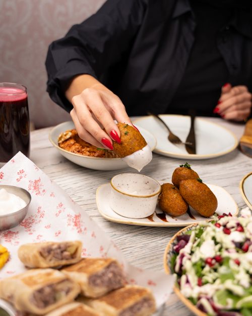 Free Indulge in Middle Eastern flavors with falafel, salad, and fresh juice on a dining table. Stock Photo