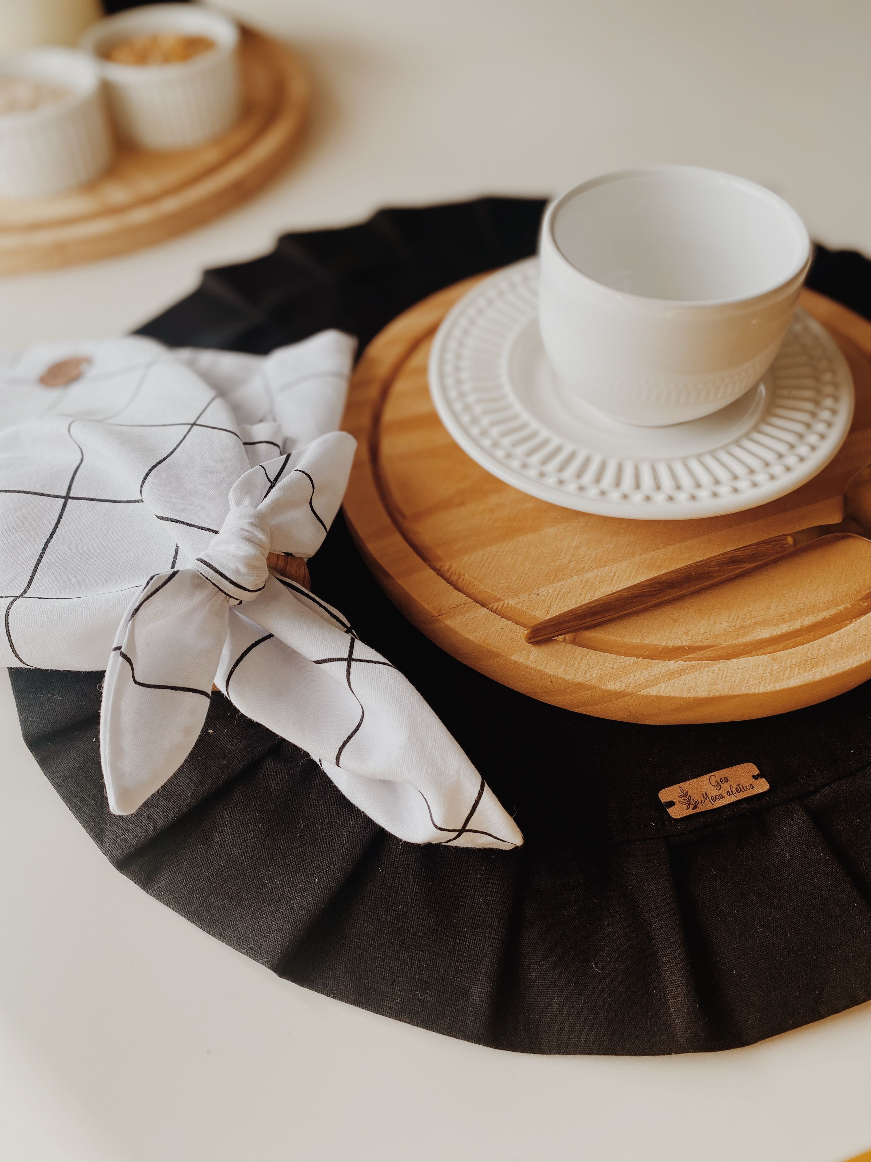 Mesa elegante com louças modernas de cerâmica branca em pratos de madeira em São Paulo.