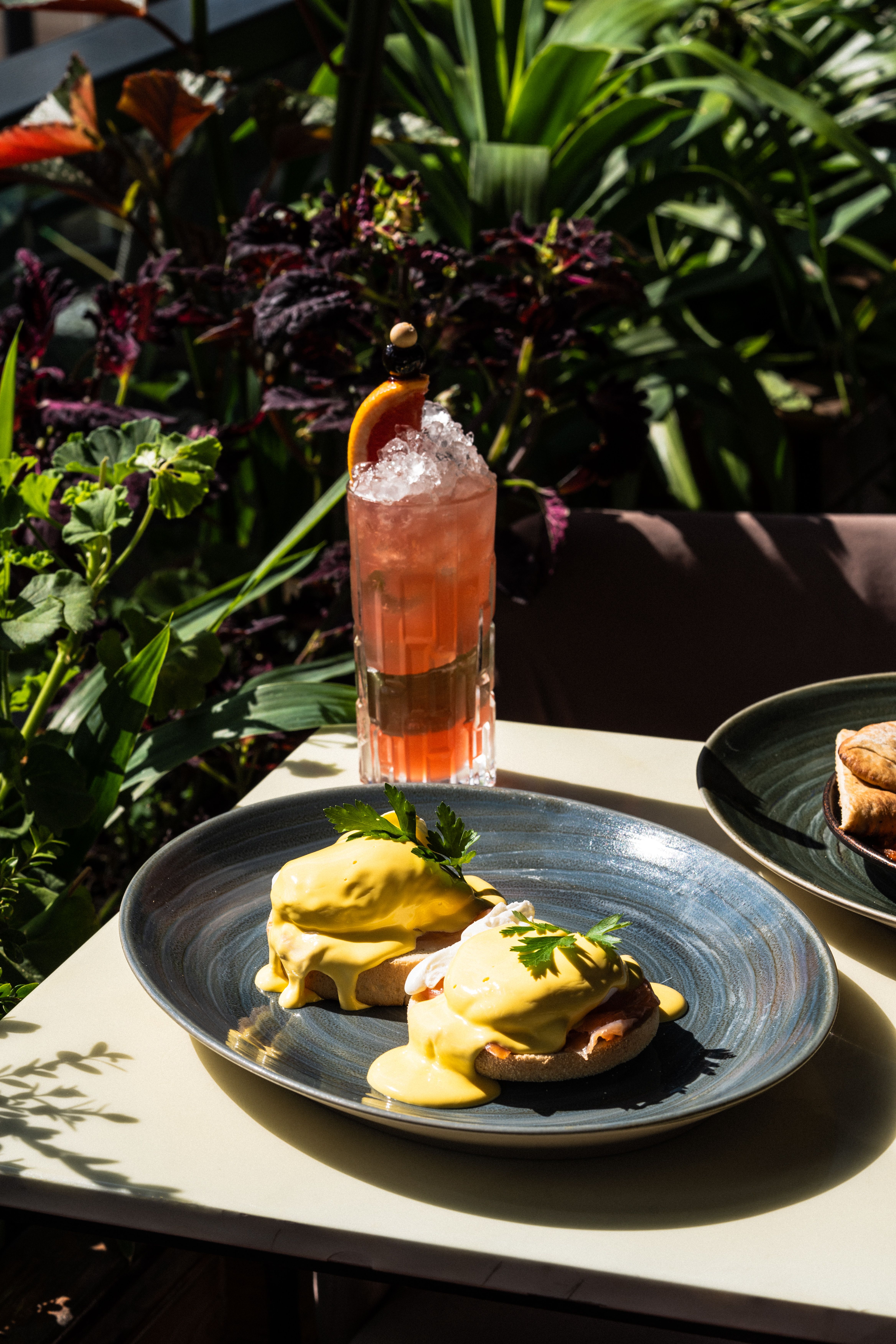 Enjoy a classic eggs benedict breakfast in the lush green ambiance of an English garden.