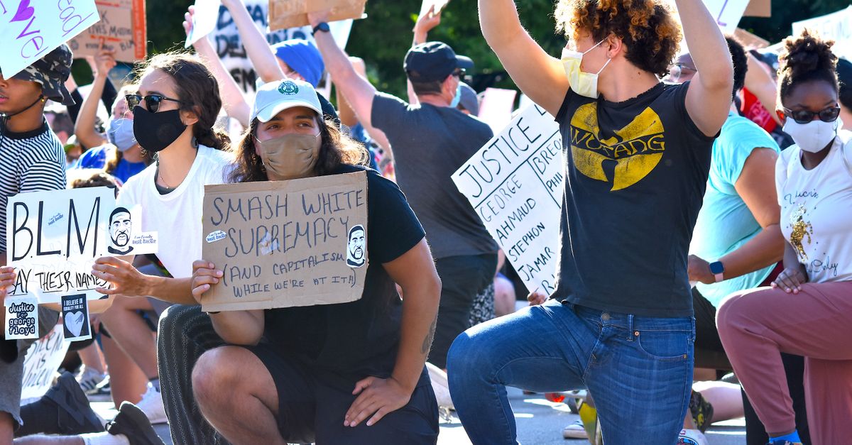 Modren Protest Protesters Kneeling with Signs at Outdoor Demonstration · Free Stock Photo