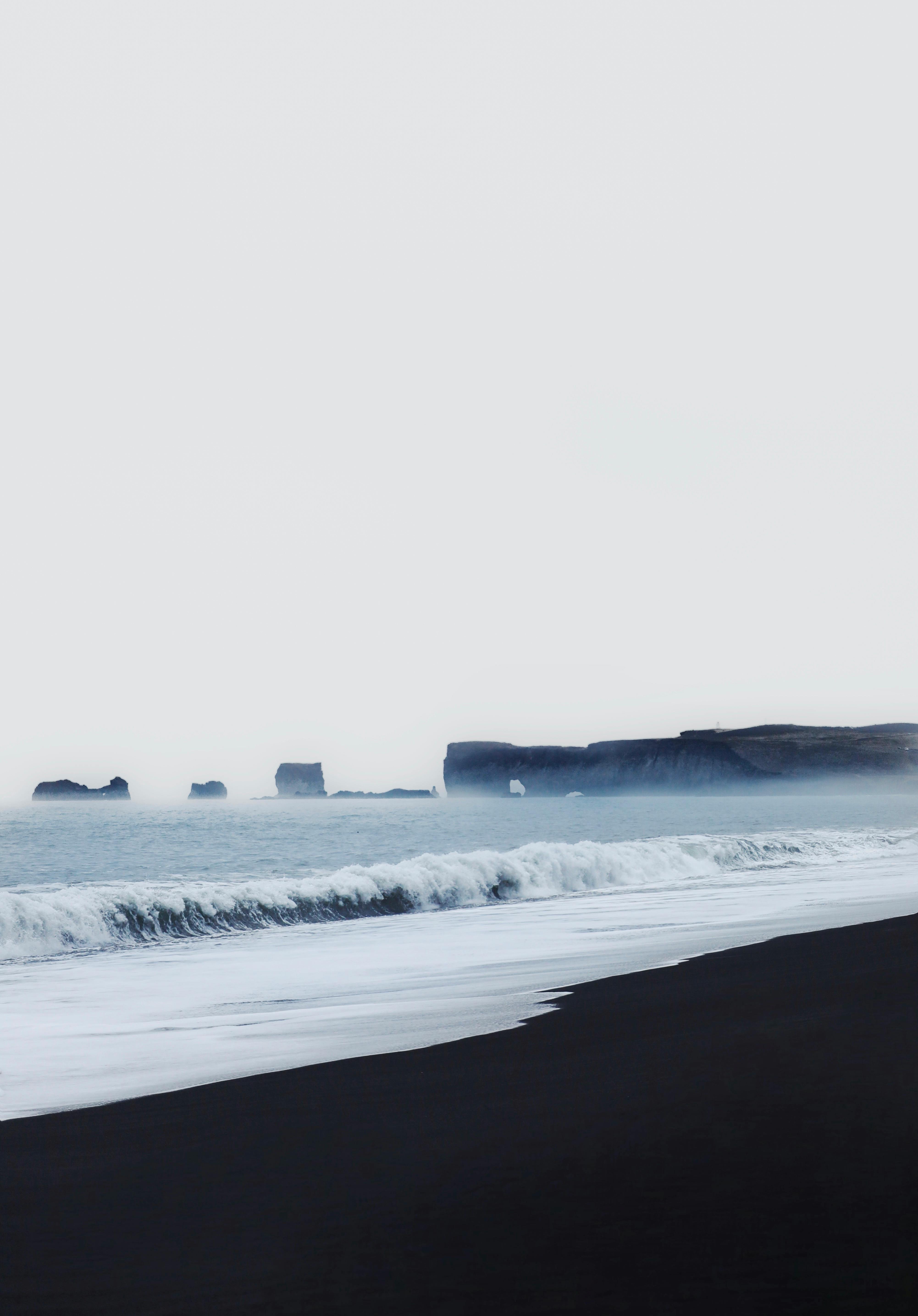 Gratis Cautivadora vista de la icónica playa de arena negra de Islandia con olas del océano. Foto de stock