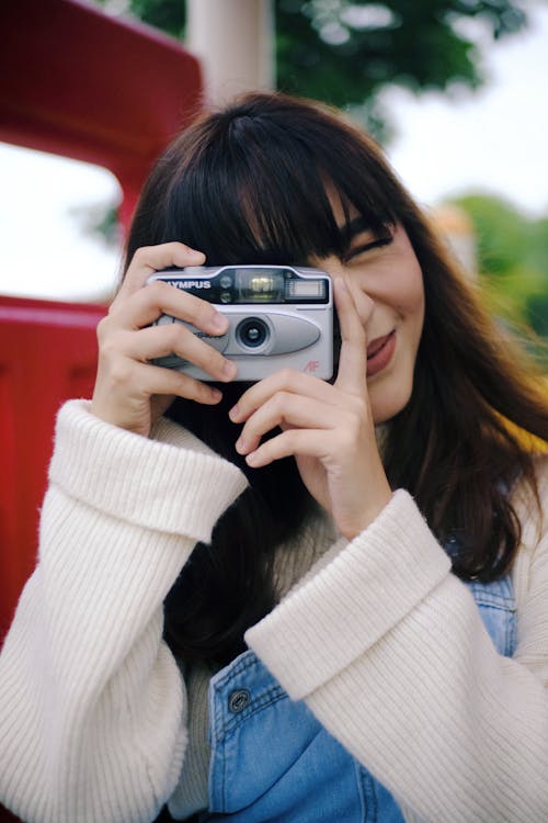 Woman Wearing White Sweater Using Camera