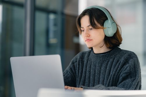 Fondatoarea Tornaviq lucrând la laptop cu căști