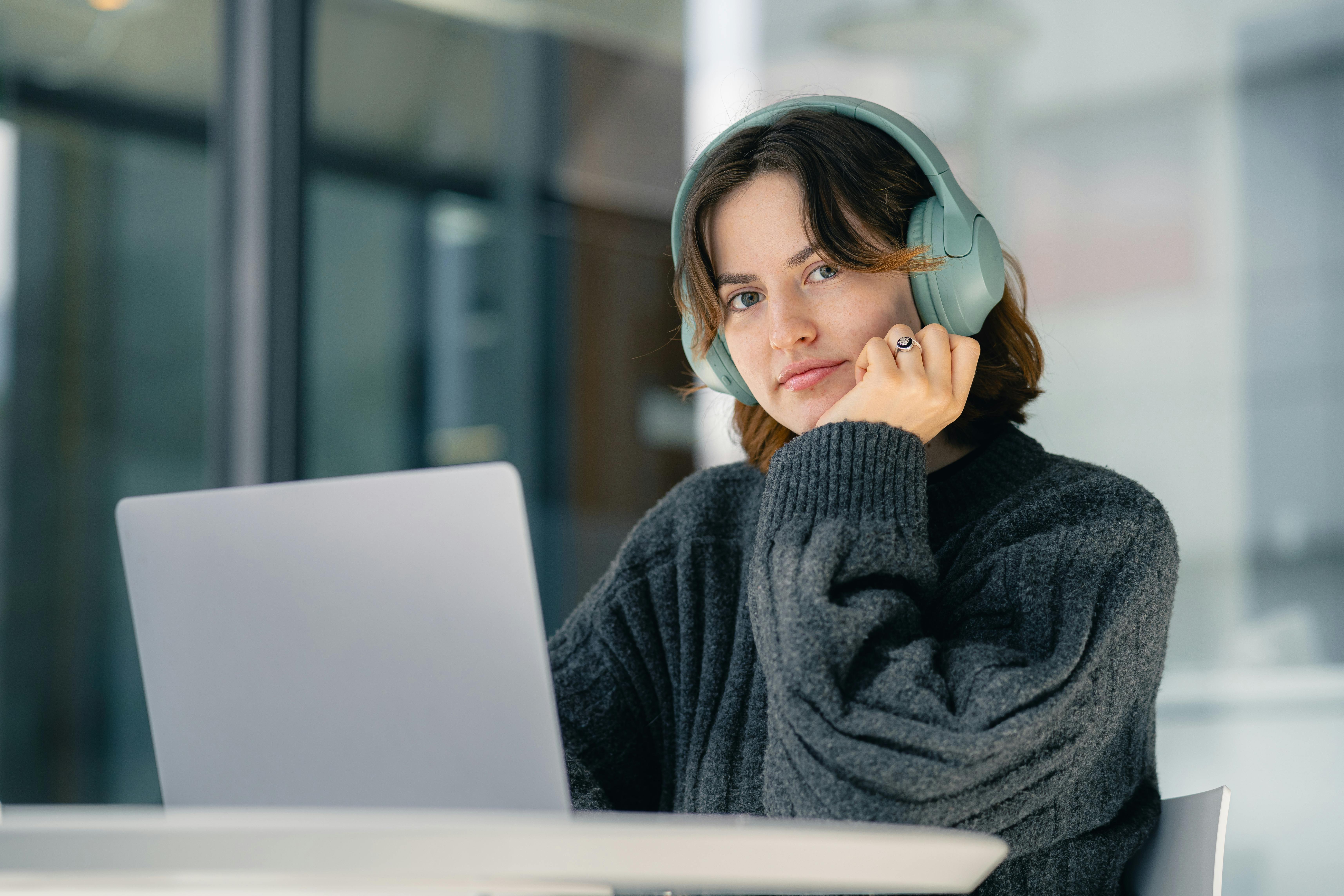 woman in headphones working on laptop indoors