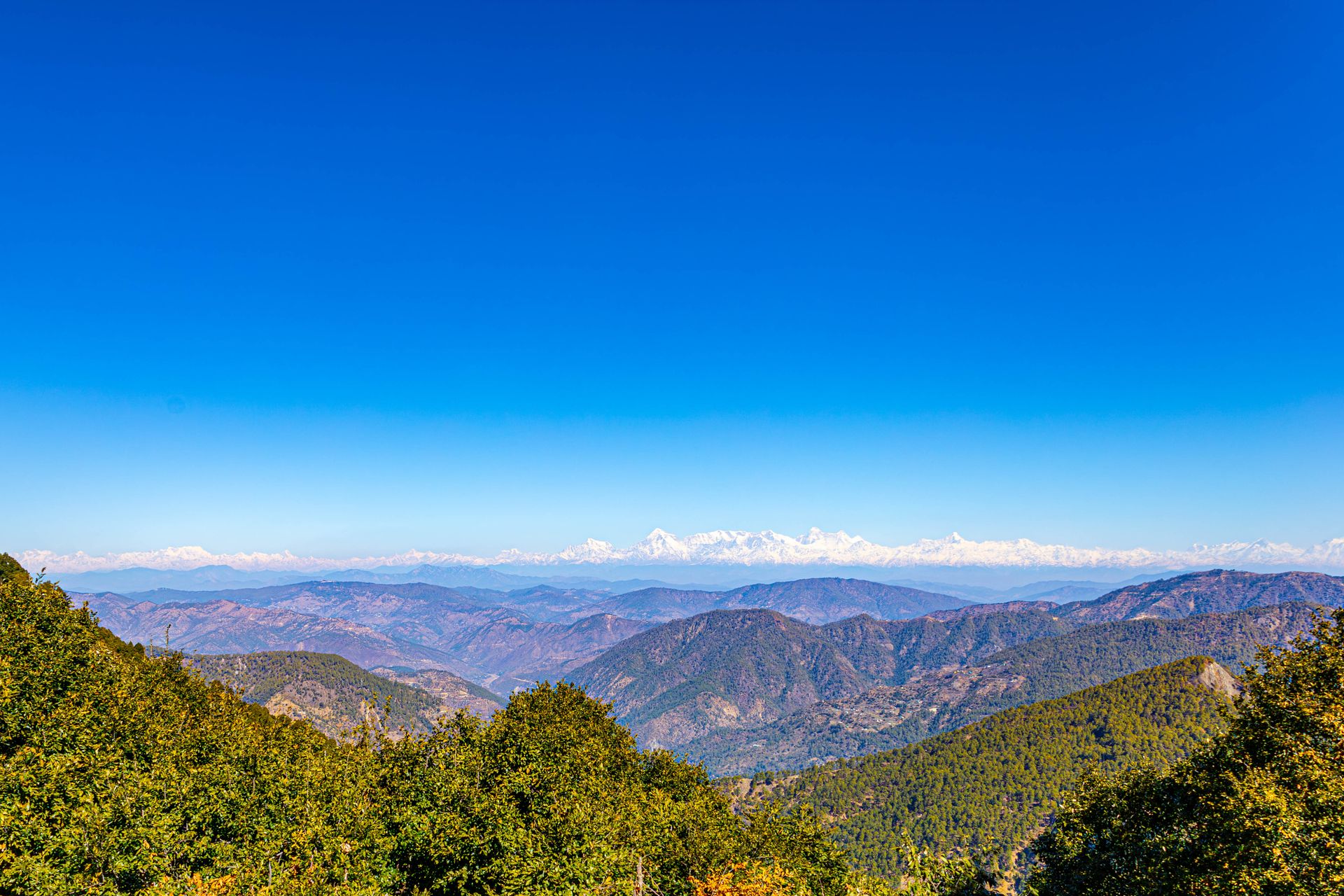 Breathtaking panoramic view of a mountain range under a bright clear blue sky.