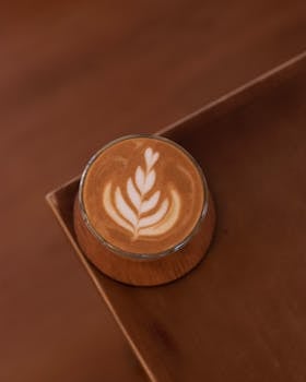 Top view of a beautifully crafted latte art coffee on a wooden table.