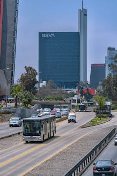 Busy street scene in Lima, Peru featuring the BBVA skyscraper and surrounding cityscape.