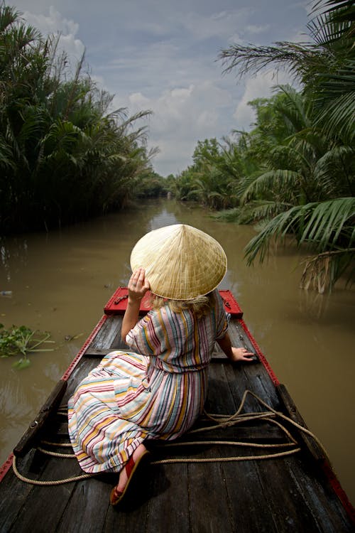 Free Back View of a Person Wearing Coolie Hat while Sitting on a Raft Stock Photo