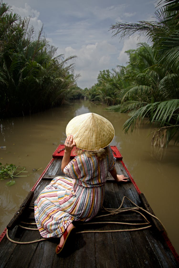 Back View Of A Person Wearing Coolie Hat While Sitting On A Raft