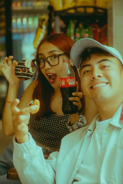 Free Two friends having fun at a cafe with drinks and desserts. Stock Photo