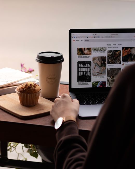 Fotomural Un entorno de trabajo acogedor con una taza de café, muffin y portátil crea una ambientación productiva.