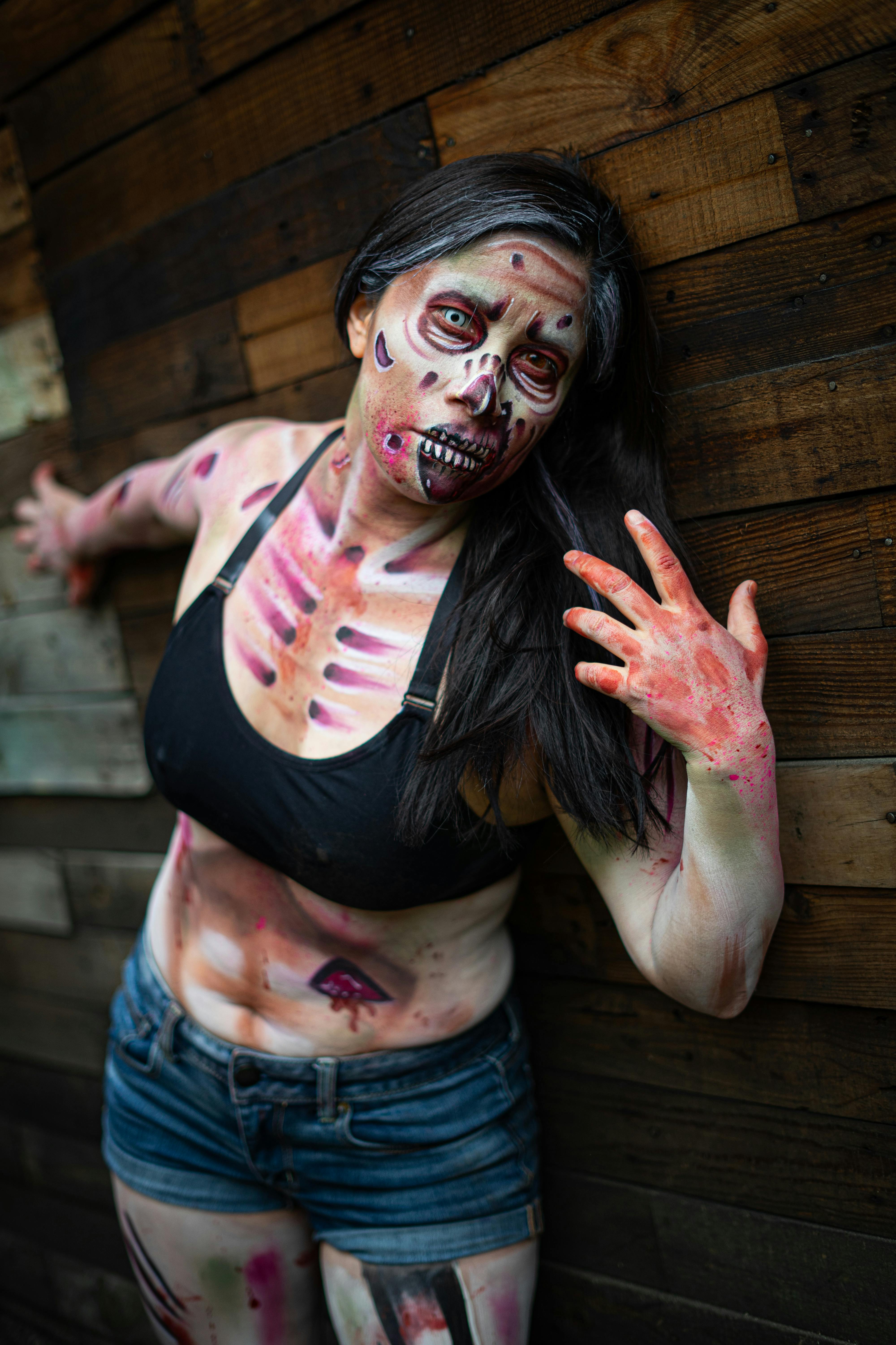 Creative portrait of a woman in zombie makeup against a wooden wall