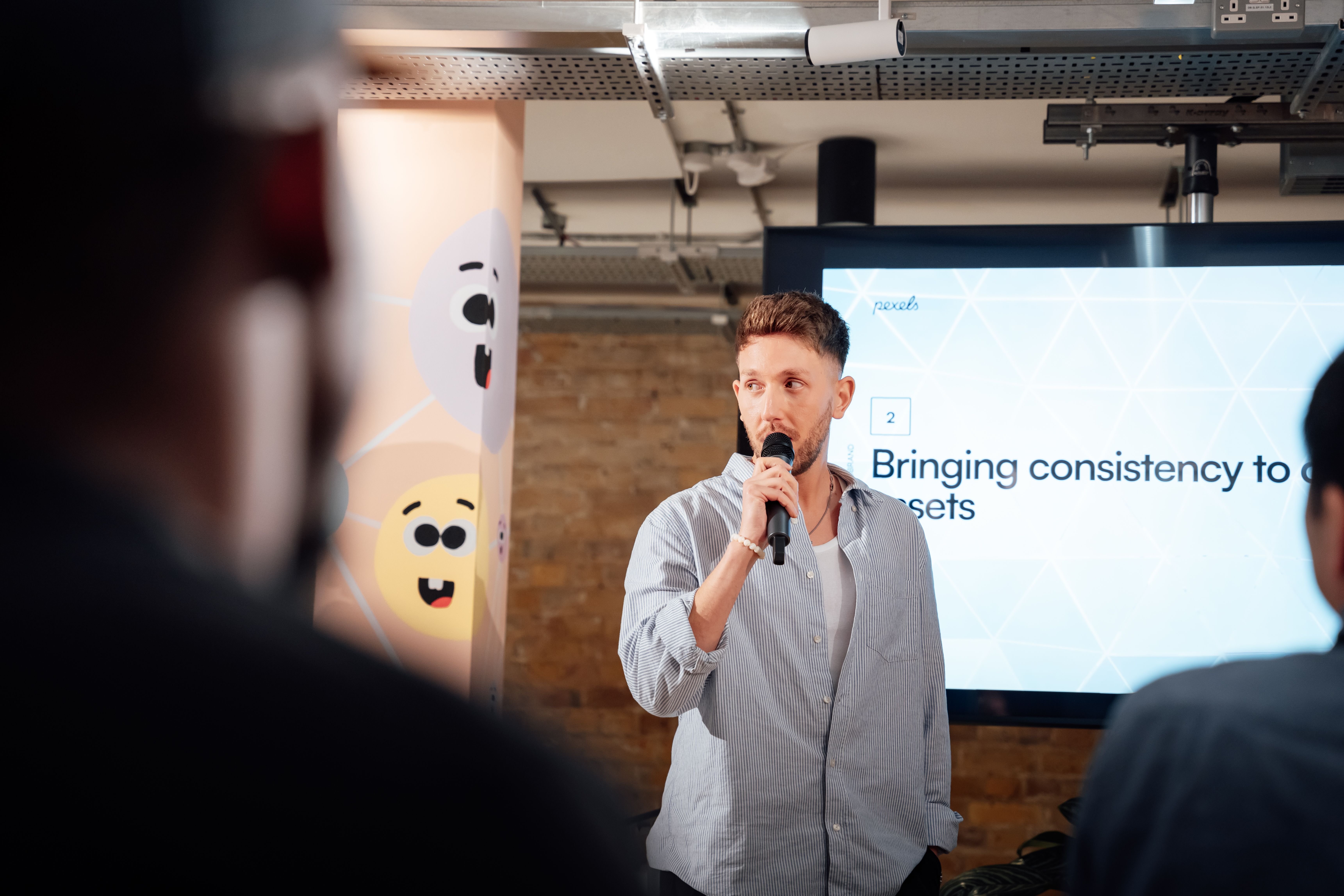 Free Man presenting with microphone at a business event in London, engaging audience. Stock Photo