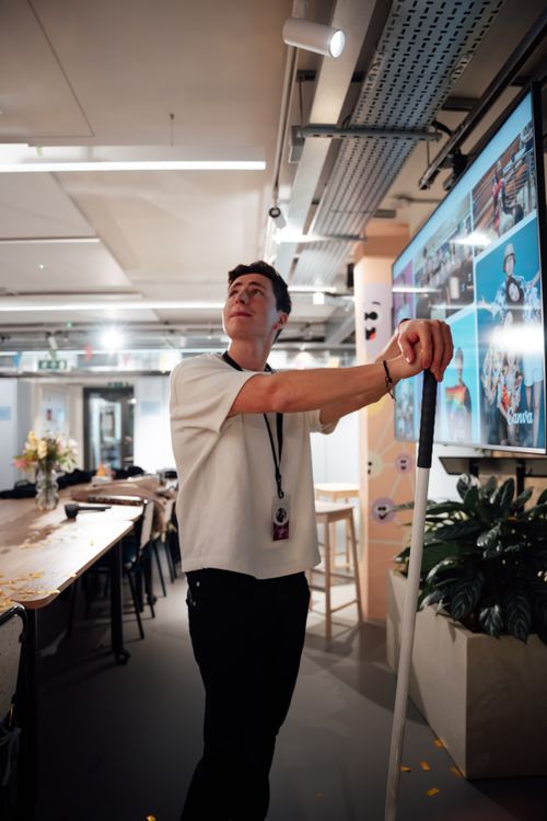 Free Man in a modern office standing near a digital screen. Indoor scene. Stock Photo