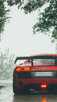Capture of a red Audi R8 supercar parked on a rainy street in Kasauli, India.
