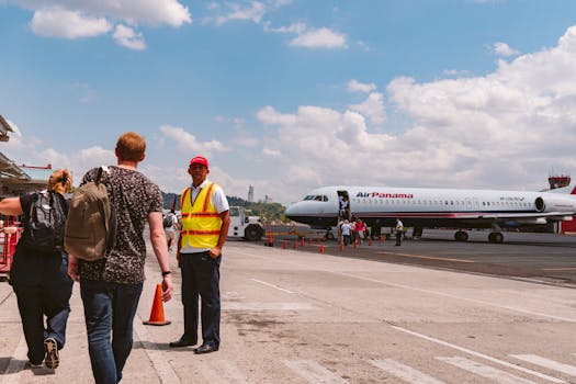 Travelers are boarding an Air Panama aircraft at an airport on a clear, sunny day. Aviation activity captured.