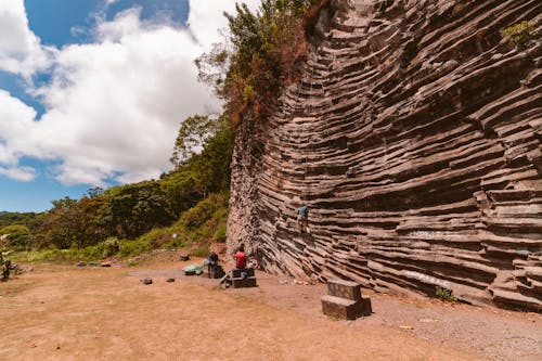 Person Sitting Beside Cliff