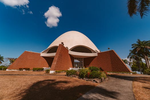 一座拥有圆顶和砖砌立面的现代建筑，矗立在晴朗的蓝天下