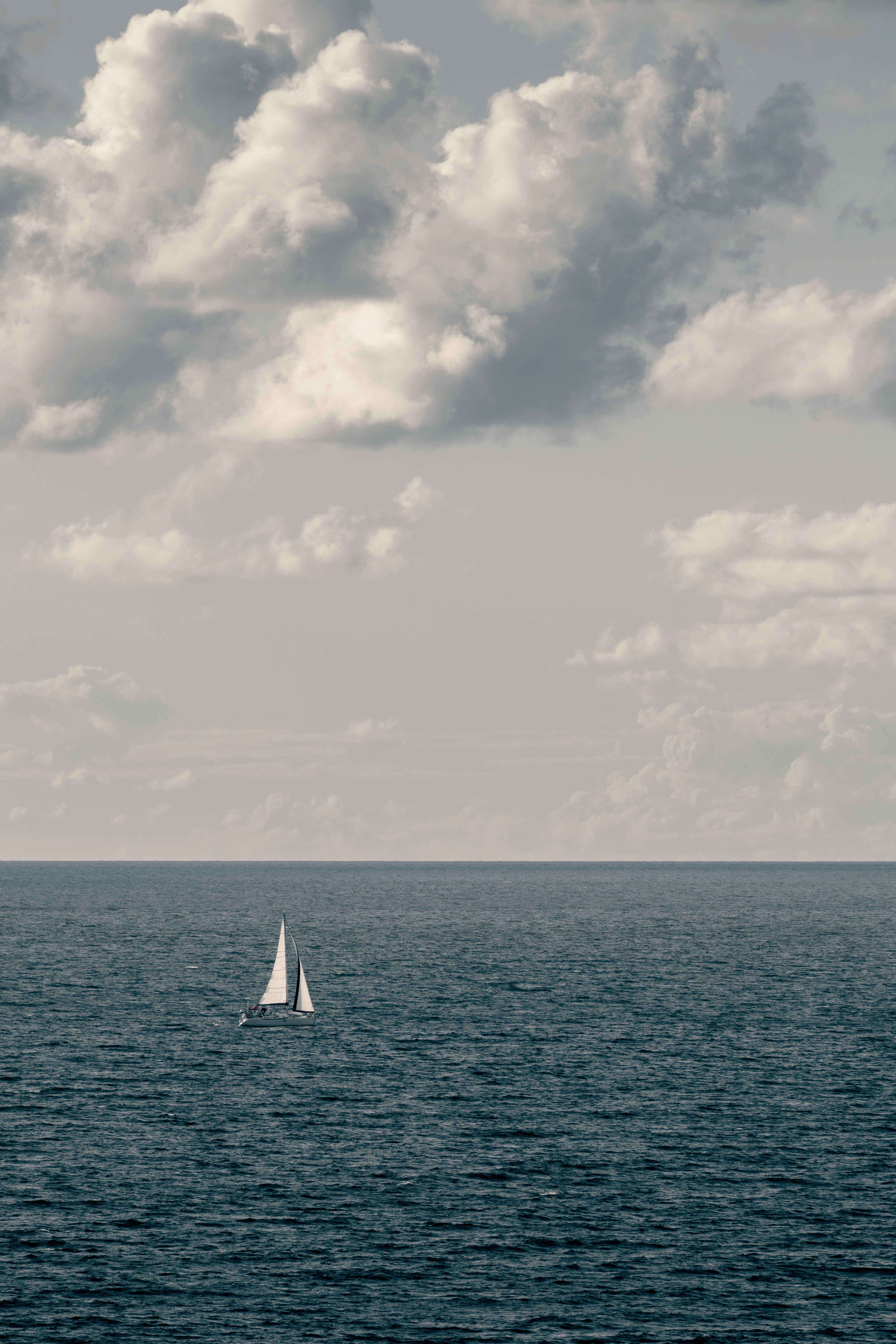 Voilier solitaire sur l'Atlantique sous un ciel nuageux