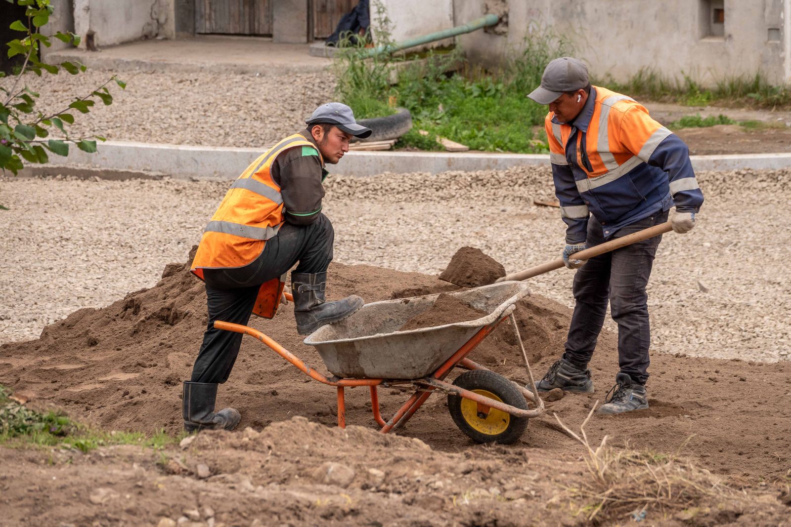 Construction workers moving aggregate on a project site
