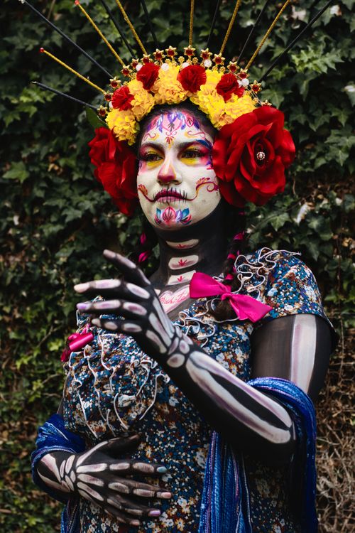 Free A vibrant Day of the Dead costume with intricate face paint and floral crown. Stock Photo