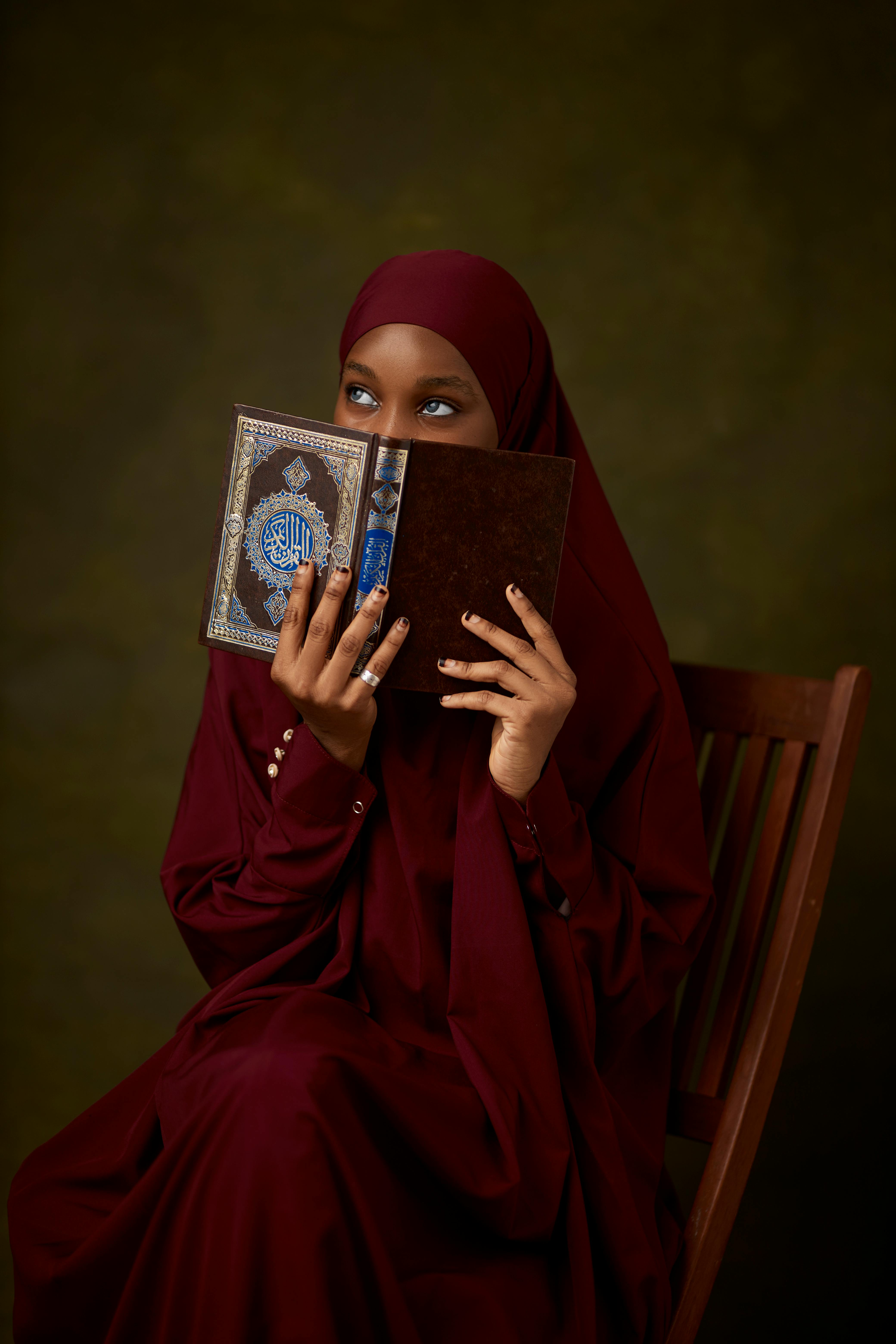 young muslim woman reading religious text indoors